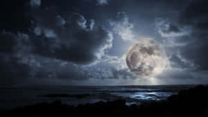 月光穿透暴風雲，照耀在夜晚黑暗的海洋之上。 — 月色夜空 壁紙
