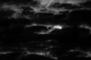 月亮部分被暗雲遮蔽在單色夜空中。 — 月色夜空 壁紙