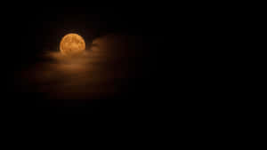 夜空中一輪發光的橙色滿月，部分被烏雲遮蓋。 — 夜空 壁紙