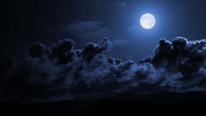 滿月穿過烏雲照耀著夜晚的山巒輪廓。 — 月色夜空 壁紙