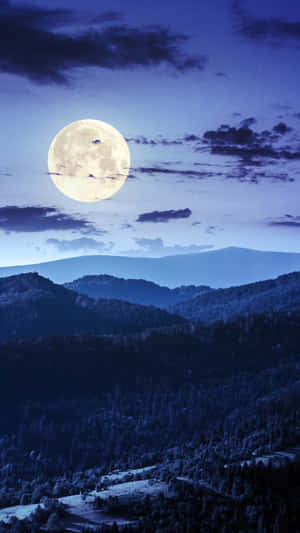 滿月照亮了繁星夜空下積雪覆蓋的山巒。 — 月色夜空 壁紙