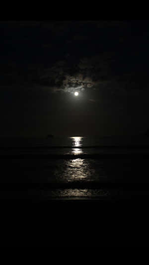 月光在烏雲下反射在平靜的海浪上。 — 月色夜空 壁紙