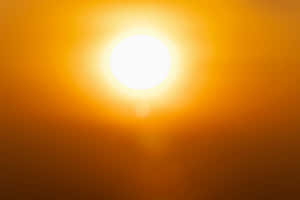 明亮的太陽在天空中投射出溫暖的橙色光芒。 — 橙色美學 壁紙