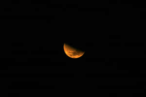 在黑色夜空中發出橙色光芒的新月。 — 月色夜空 壁紙