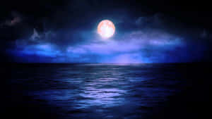 滿月在黑暗的海洋上閃耀，伴隨著藍色的雲 — 夜空 壁紙