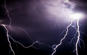 強大的閃電以紫色和白色閃光照亮了黑暗的暴風雨天空。