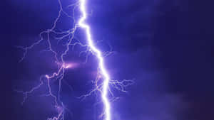 強烈的閃電劈開黑暗的暴風雨天空，帶有電光紫色調。 — 雷暴 壁紙