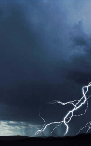 一道強大的閃電照亮了黑暗景觀上方暴風雨的夜空。 — 雷暴 壁紙