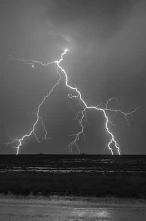 一道強大的閃電照亮了平坦田野上空黑暗的暴風雨天空。 — 小米Pad 8 Pro 壁紙