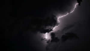一道明亮的閃電在夜間穿過黑暗的暴風雲層分叉。 — 夜空 壁紙