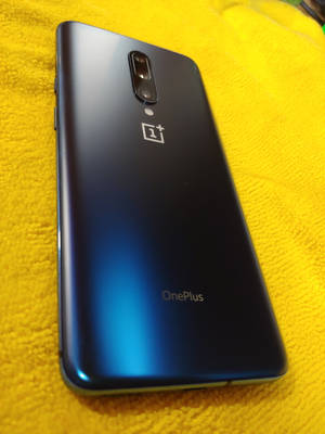 藍色 OnePlus 手機在黃色毛巾上 — OnePlus 壁紙