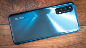 木桌上的藍色 realme 智能手機 — Realme 壁紙