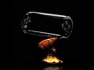 黑色 Sony PSP 主機在黑暗的攝影棚環境中放置在發光的橙色蘑菇上。 — PlayStation GIF 壁紙