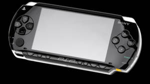 黑色和銀色 Sony PSP 遊戲機，配備空白屏幕和發光的電源按鈕。 — PlayStation GIF 壁紙
