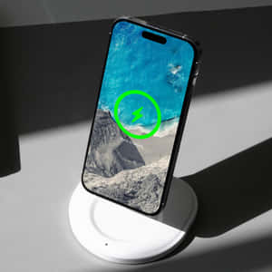 智能手機在無線充電器上顯示海洋壁紙和 100% 充電狀態。 — 1:1 壁紙