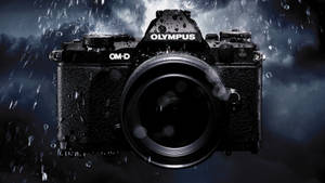 黑色Olympus OM-D相機在暴雨中，背景風暴。 — 雨 壁紙