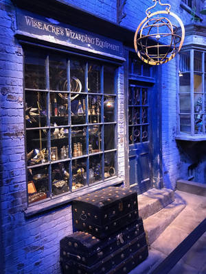 夜晚的Wiseacre's Wizarding Equipment商店，藍色燈光和堆疊的行李箱。 — 哈利波特 壁紙