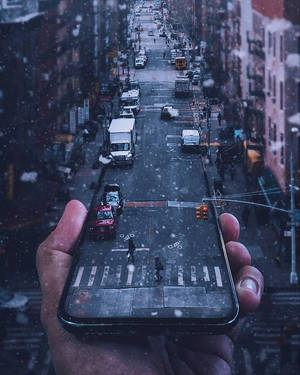 手拿著手機，顯示積雪街道，有汽車和行人。 — 美學手機GIF 壁紙
