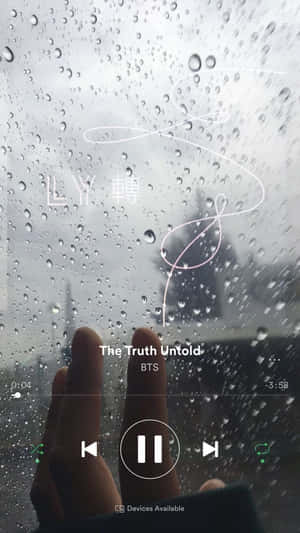 手觸摸帶有雨痕的窗戶，音樂播放器顯示BTS歌曲。 — iPhone 8 壁紙
