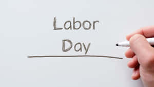 手在白色表面上用記號筆寫Labor Day。 — 美國國旗 壁紙