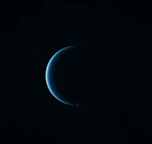一顆發光的藍色新月形行星，在星空虛空中有一顆小衛星繞行。 — 行星 壁紙