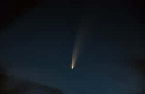 一顆帶有長尾巴的明亮彗星在繁星點點的夜空中閃耀。 — 月色夜空 壁紙