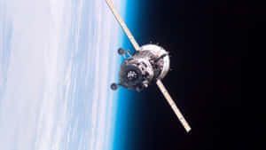 地球上空軌道上的衛星，顯示藍色大氣層和黑色太空 — 天空景觀 壁紙