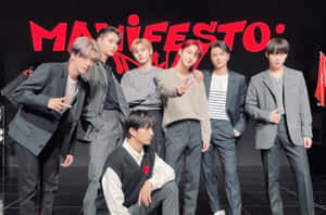 七位時尚K-pop偶像在舞台上穿著灰色西裝和休閒服裝擺姿勢。 — 美學筆電 壁紙