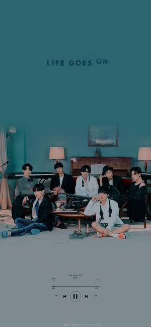 七位K-pop偶像在青綠色客廳中，與音樂設備和歌曲播放器疊加層一起擺姿勢。 — iPhone 11 壁紙