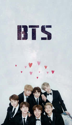 七個著禮服嘅男人喺閃爍嘅BTS標誌同漂浮嘅心形下面一齊微笑。 — Galaxy Tab A 壁紙