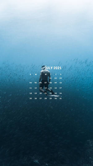 一名潛水員被魚群環繞，顯示2021年7月的日曆。