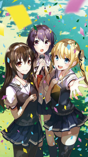 三個穿著校服的動畫女孩在戶外用五彩紙屑慶祝。