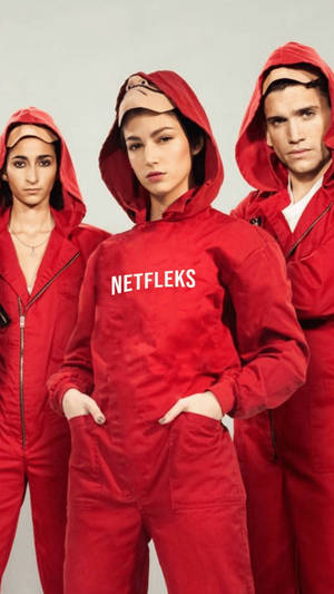 三個穿著帶有 'NETFLEKS' 文字的紅色連身衣的模特兒在攝影棚中擺姿勢。 — Netflix GIF 壁紙
