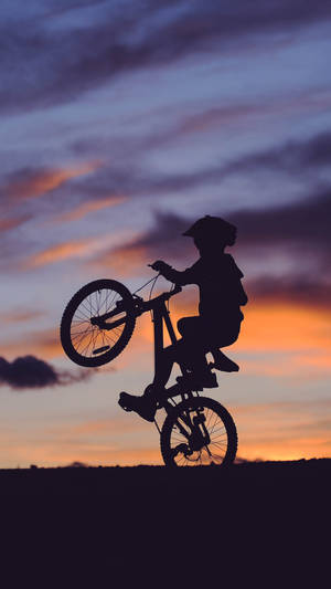 孩子在日落時騎單輪單車
