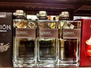 商店貨架上的三瓶Corzo tequila，附有品牌包裝。