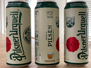 窗邊木桌上的三罐Pilsner Urquell啤酒罐。