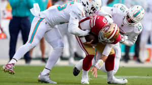 足球運動員在比賽中擒抱四分衛。 — NFL 美式足球 GIF 壁紙