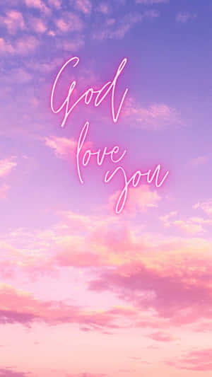 霓虹字體 God love you 映襯著粉彩日落天空。