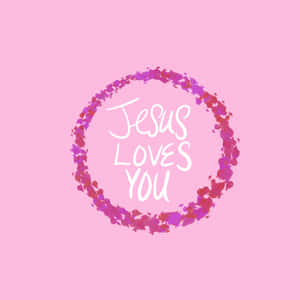 粉紅色背景上，彩色水彩花環內有白色草書「Jesus Loves You」文字