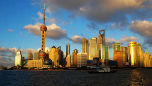 上海天際線在夕陽下，金色摩天大樓和江上船隻 — 唐人街 GIF 壁紙