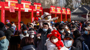 一群戴著口罩的人們在一個紅色裝飾的戶外節日活動中。 — 唐人街 GIF 壁紙