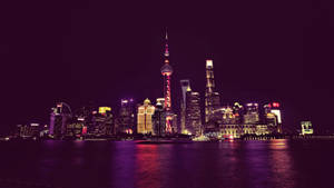 夜晚的上海天際線，發光的建築物倒映在水中。 — 唐人街 GIF 壁紙