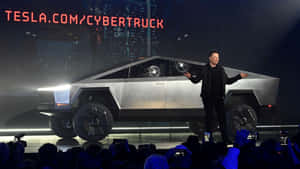伊隆·馬斯克在燈光明亮的舞台上展示 Tesla Cybertruck，觀眾在拍攝。