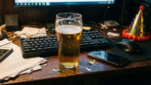 雜亂的桌子上有一杯啤酒，還有派對帽和電腦設備。 — 桌面 壁紙