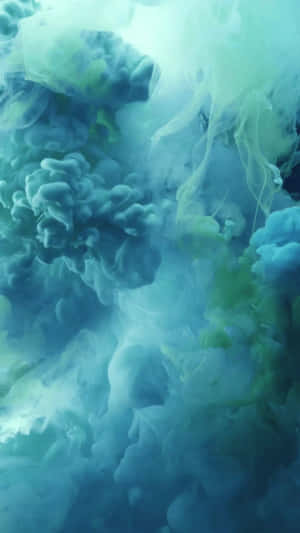 藍色和綠色墨水在水中旋轉，營造出夢幻般的抽象圖案。