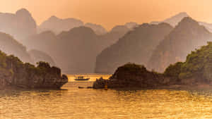 一艘小船在金色海灣中航行於岩石島嶼之間。