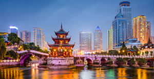 河上的傳統中式亭閣與黃昏的現代城市天際線 — 唐人街 GIF 壁紙