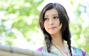 年輕女子編著辮子，在陽光明媚的花園中向上看。