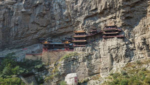 建在陡峭懸崖上的古老寺廟，有木製陽台和紅色屋頂。