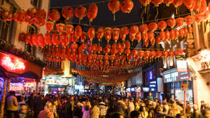 夜晚擁擠的街道，掛滿紅色燈籠慶祝中國節日。
